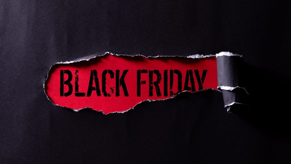 Top view of Black torn paper and the text black friday on a red background. Black Friday composition.