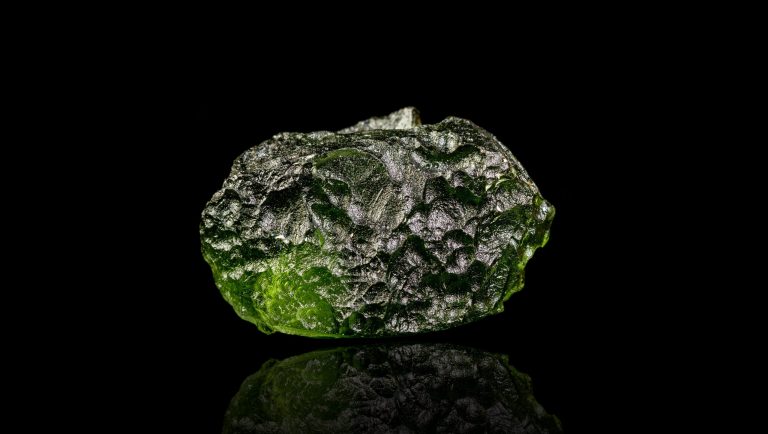 macro stone mineral Moldavite on a black background close-up